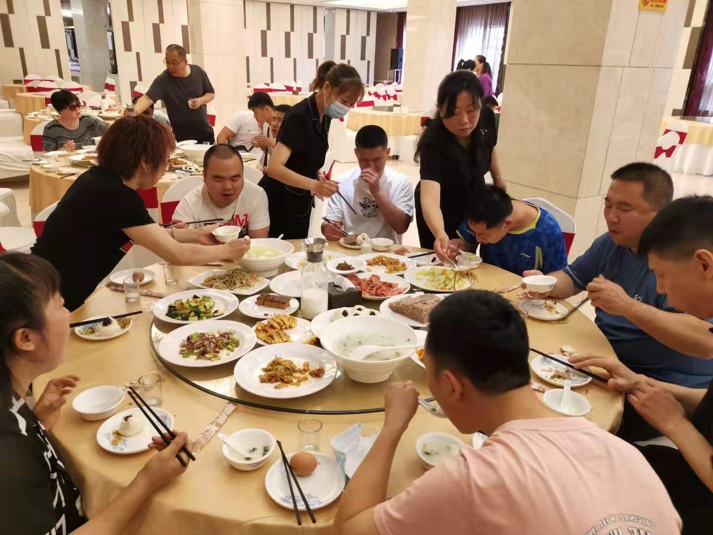 图为工作人员进行就餐帮扶